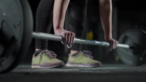 Caucasian Athletic Female Performs a Deadlift with Barbell Lifts Barbell and Does Weights Training