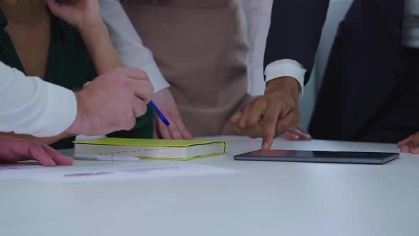 Hands of Managers Touching and Pointing at Tablet at Meeting