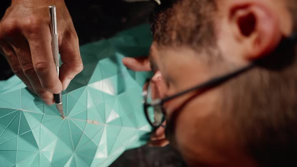 Close-up: a male artisan, a sculptor applies a solution of paint and putty to the product, handmade.