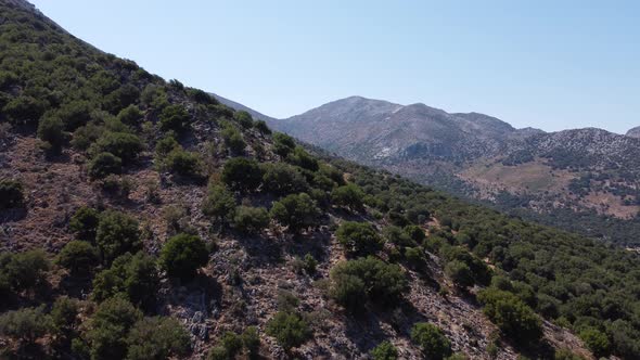 Beautiful Aerial Tracking Shot of the Tall and Majestic Mountains in Crete Greece with the Deep Blue