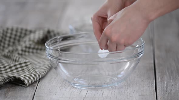 Female Hands Breaking an Egg and Separating Yolk From White