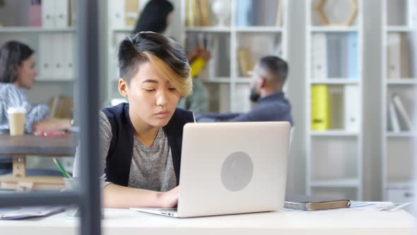 20-something Asian Employee Working on Laptop