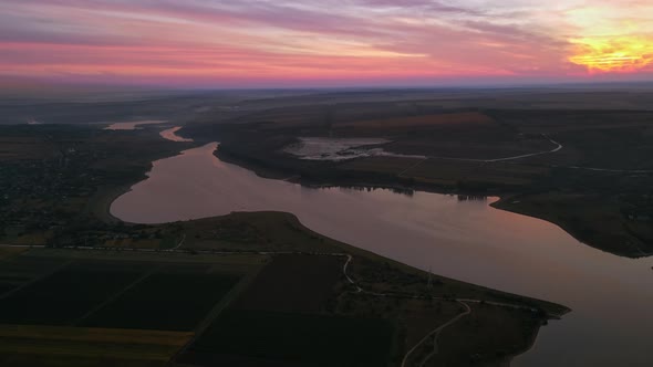 Aerial drone view of the Duruitoarea natural reservation at sunset in Moldova. River and village, hi