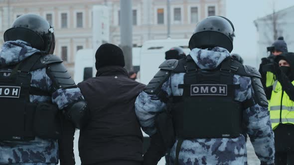 Police Officers From Riot Unit in Protective Gear Escort Suspect Protesters