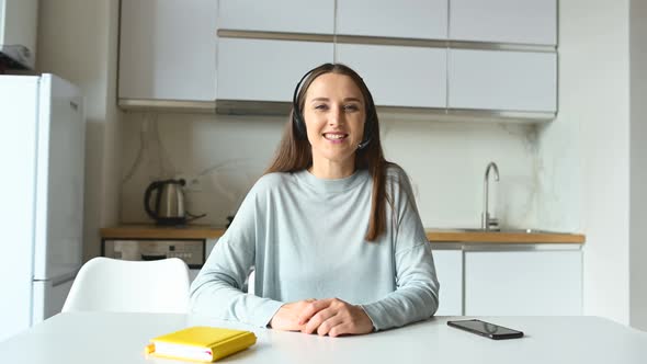 Young Woman Wearing Headset Using Laptop for Video Call