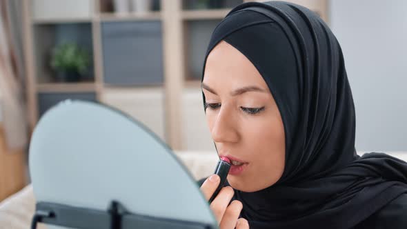 Closeup Arabic Woman in Black Hijab Applying Lipstick in Front of Mirror Use Moisturizer Lip Gloss