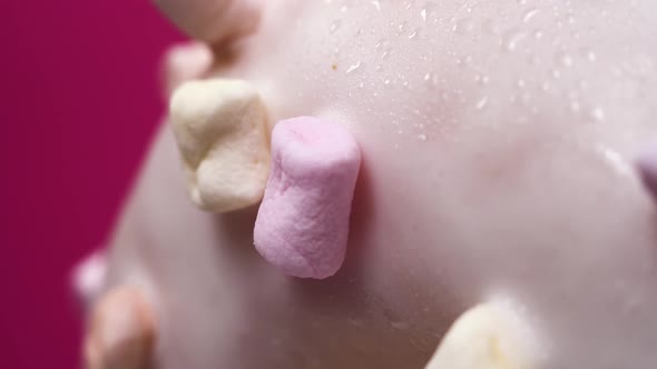 Macro Footage of Beautiful Pink and White Donut with Marshmallows. Sweets Rotate on Pink Background