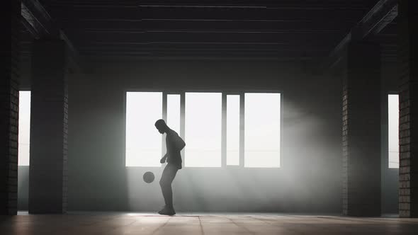 Teenager Boy Football Soccer Player Practicing Tricks Kicks and Moves with Ball Inside Empty Covered
