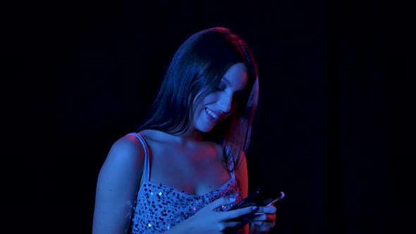 Portrait of Charming Young Woman Is Texting on Her Phone. Close Up. Slow Motion.