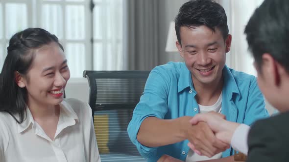 Close Up Of Asian Couple Receives The Keys From A Real Estate Agent Before Shaking Hands
