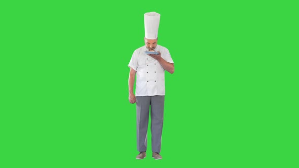 Mature Chef Cook or Baker Holds Plate with Dessert and Making Approval Gesture on a Green Screen