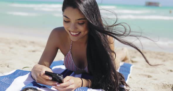 Pretty Girl Using Phone on Beach