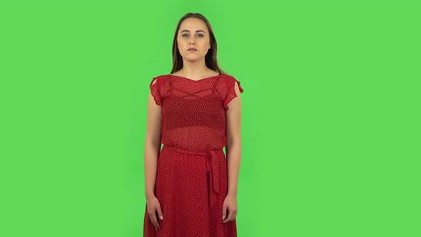 Tender Girl in Red Dress Is Frightened Then Sighs with Relief and Smiles. Green Screen