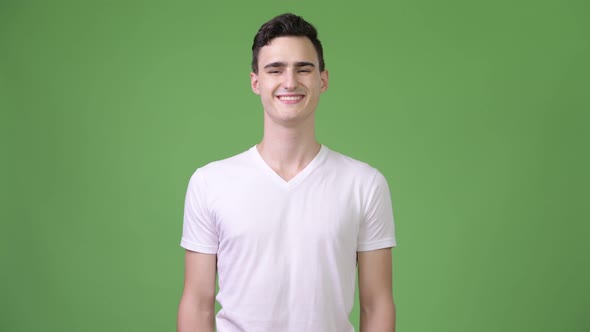 Young Happy Handsome Man Smiling Against Green Background