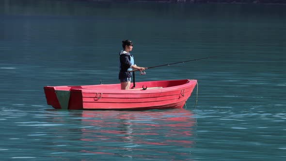 Woman on the Boat Catches a Fish on Spinning in Norway