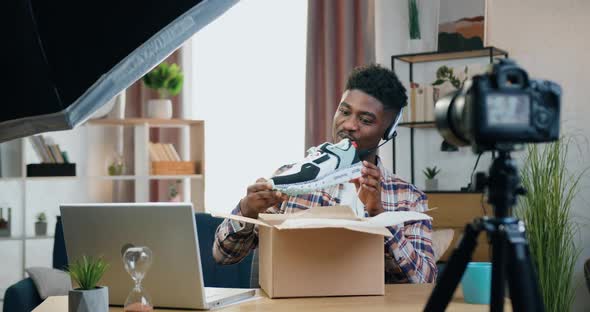 Black-Skinned Guy in Headphones Making Unpacking on Camera During Recording Video