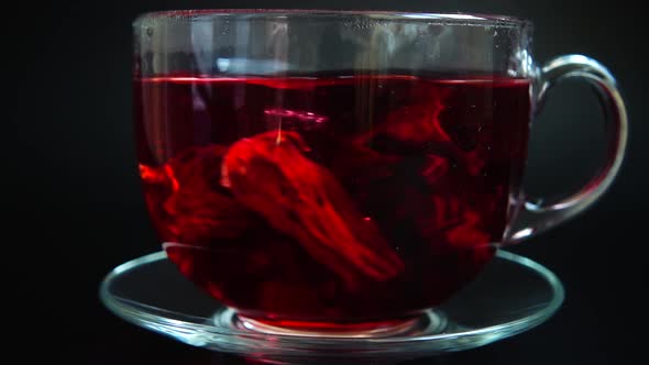 Preparation of Hibiscus tea in a glass cup.