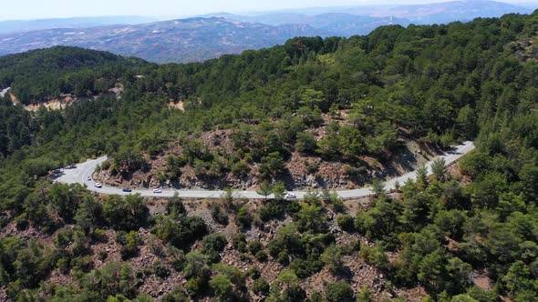 The Car Drives on the Highway Among the Mountains