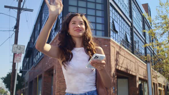 Asian Girl Waving Hand to Someone on Street Closeup