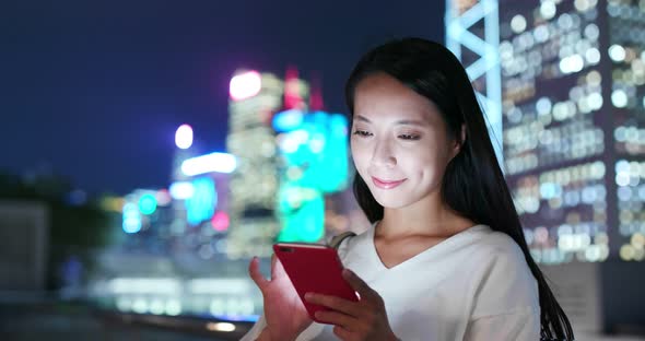 Woman use of mobile phone in city at night