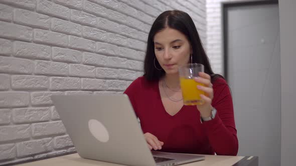 Woman Freelancer Working with Laptop Drinking Orange Juce Remote Work Home