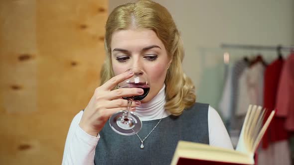 Relaxed Woman Reading Book and Drinking a Glass of Red Wine