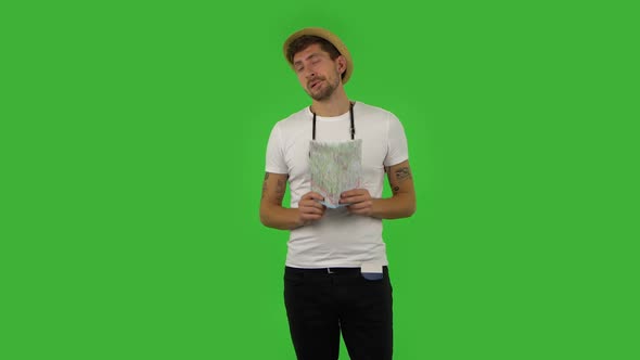 Tourist in a Hat with a Retro Camera and Map Looking Tired. Greenscreen