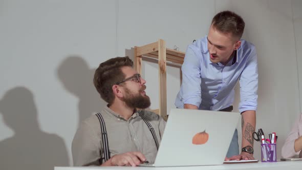 Two Men Are Communicating in Office in Working Day One Is Sitting at Laptop