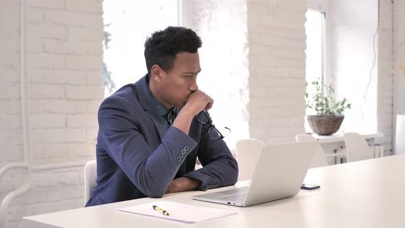 Pensive Businessman Thinking and Working on Laptop