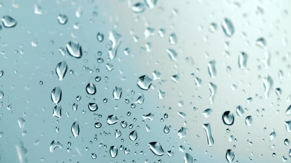 Raindrops run down the glass on a beautiful out of focus background in close-up macro.