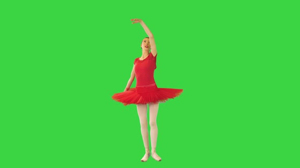 Young Ballerina in Red Classical Tutu Walks Demipointe and Makes Arms Movements on a Green Screen