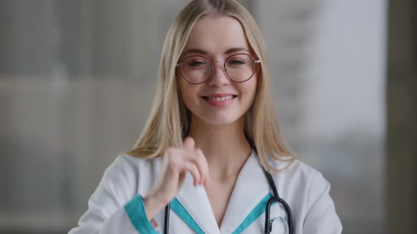 Female Medical Worker Doctor Woman in Glasses Looking at Camera Shows Thumbs Up in Hospital Clinic