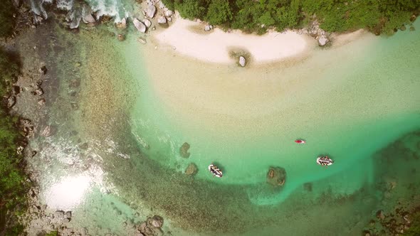 Aerial view of people doing rafting surrounded by rocks at Soca river, Slovenia.