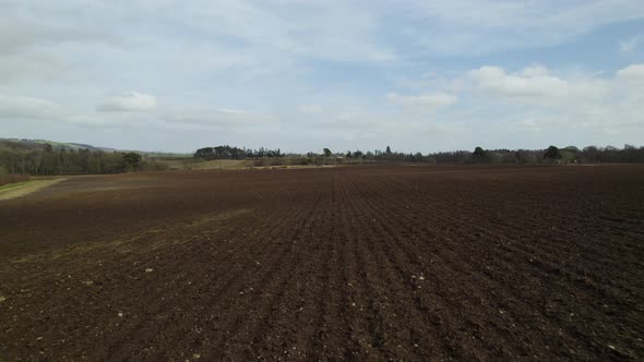 Drone flying low over freshly ploughed fields in Scotland