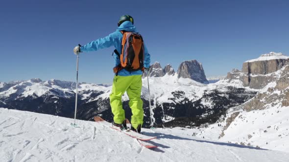 Downhill skier inspecting slope, Dolomites, Italy