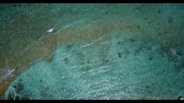 Aerial top down scenery of marine shore beach trip by blue water with white sandy background of a da