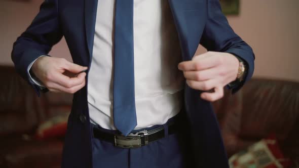 Stylish Man in a Suit Fastening Buttons on His Jacket Preparing To Go Out. Close Up, Slow Motion