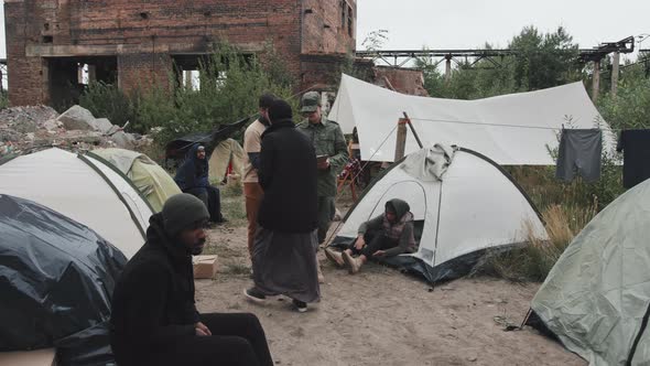 Social Worker and Police Officer Walking through Refugee Camp