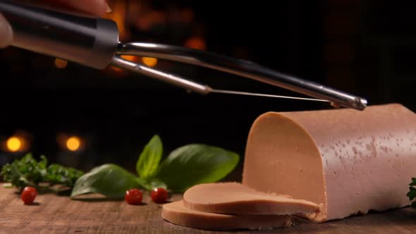 A Special String Knife Is Cutting Delicious French Foie Gras on a Wooden Board
