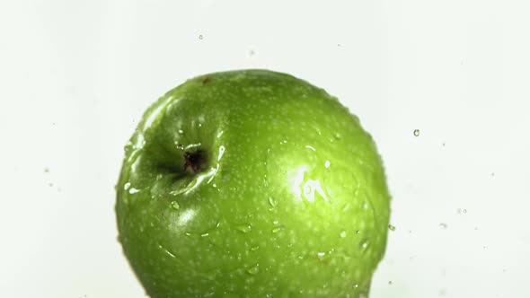 Flying of Green Apple in White Kitchen Background in Slow Motion