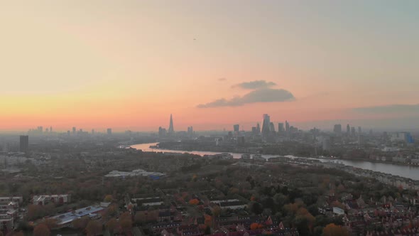 Dolly forwards drone shot over Canada water London towards city centre sunset