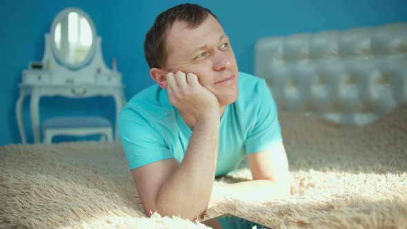 Attractive man dreaming while lying on bed in the early morning