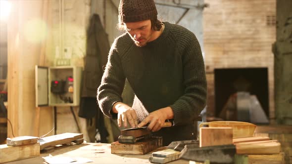 Bladesmith grinding a knife on grindstone