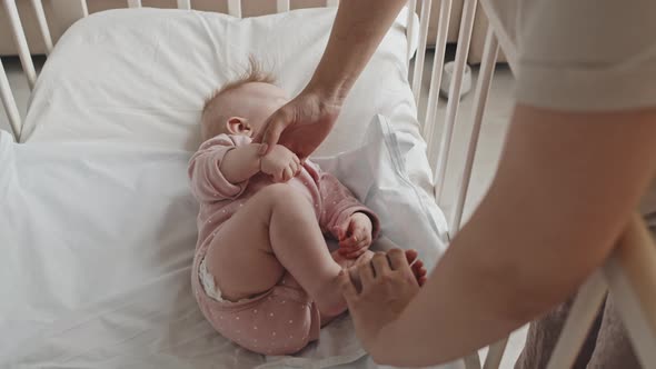 Caregiver Putting Baby in Crib