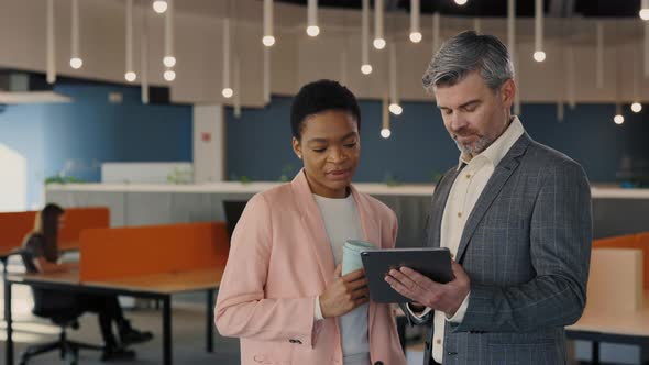 Two Diverse People in Stylish Wear Standing Together at Business Center and Discussing Common