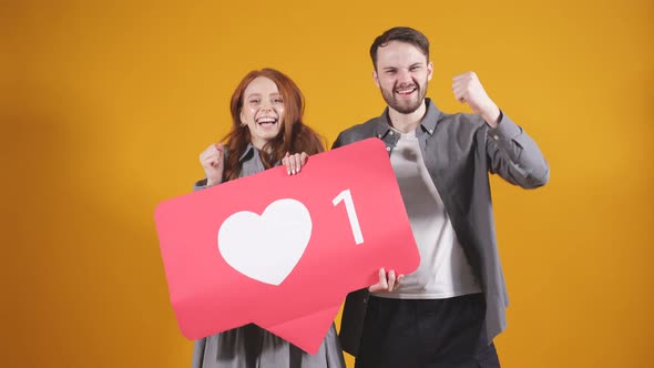 A Man and a Woman Hold a Sign of the Laika Sign on an Isolated Background