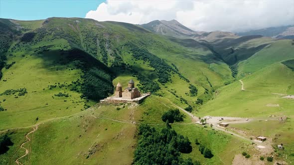 Aerial drone view of Gergeti Trinity Church in Georgia. Caucasus Mountains, church located on the to