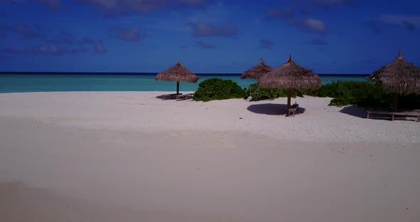 Natural fly over travel shot of a sunshine white sandy paradise beach and aqua turquoise water backg