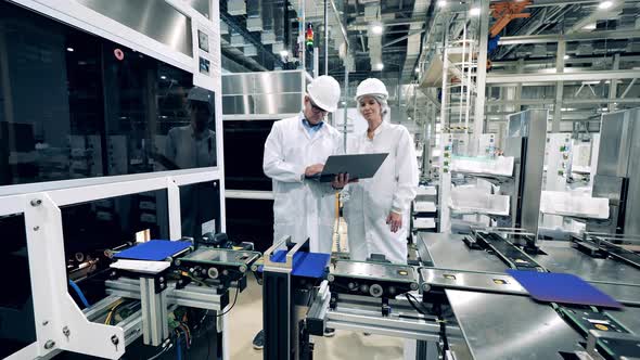 Two Engineering Experts are Observing Conveyor with Solar Cells