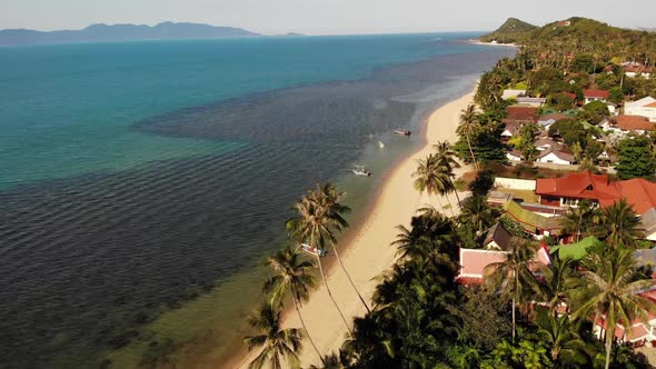 Road and Houses on Seashore. Drone View of Main Road and Coastal Cottages on Ko Samui Island on